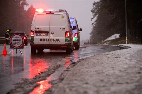 Policijos automobilis su įjungtais švyturėliais starto linijoje kartu su sportiniais automobiliais