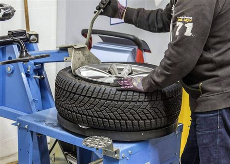 Nuotrauka: Autoserviso darbuotojas montuoja padangas