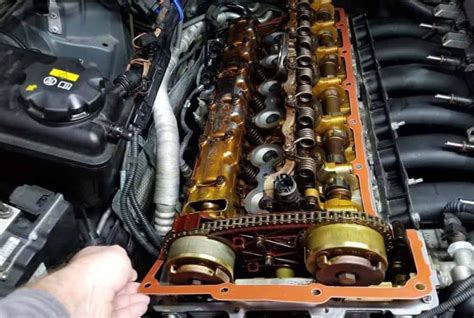 Autoserviso meistras atlieka variklio remontą