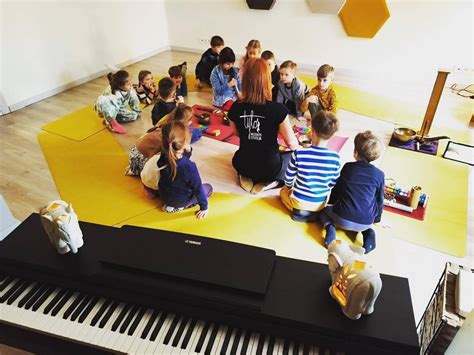 Iliustracija su dainuojančiais vaikais ir muzikos instrumentais