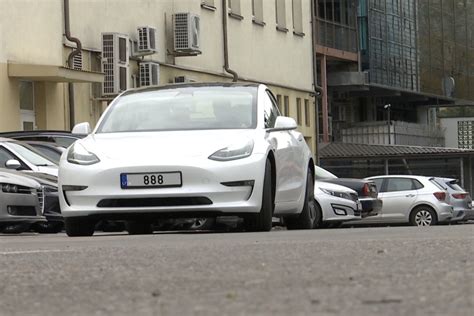 Nuotrauka, vaizduojanti seną dyzelinį automobilį ir naują elektromobilį