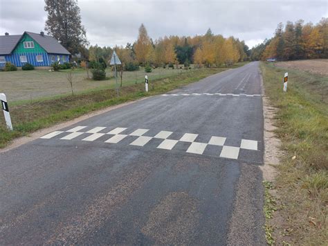 Kelio ruožas su apdaužytu dviračiu ir automobilio detalėmis