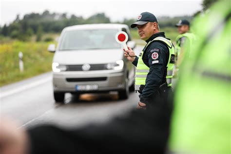 Policijos pareigūnas tikrina automobilio padangas