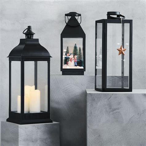 Nerūdijančio plieno žibintas su eglėmis ir žvake