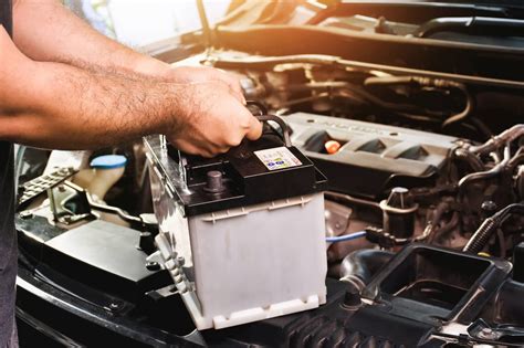 Autoelektrikas dirbantis su automobilio elektros sistema
