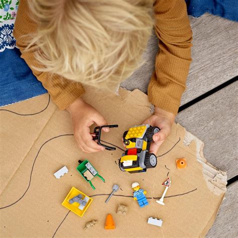 Vaikas žaidžia su LEGO City kelio elementais