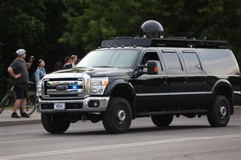 Automobilis su dviračiais ant stogo, važiuojantis pro žemą tiltą