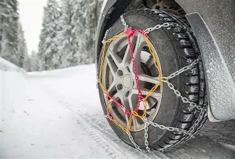 automobilis su sniego grandinėmis kalnuose