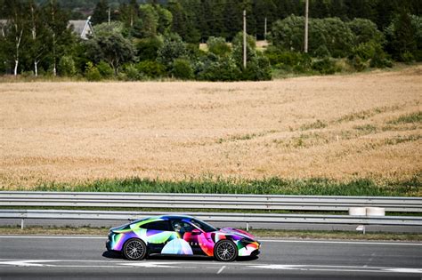 vyras vairuoja sportinį automobilį lenktynių trasoje