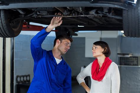 Automobilių serviso mechanikas dirbantis su varikliu