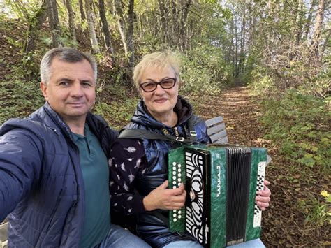 Moteris groja tamburinu ir dainuoja tradicinėje Galisijos aplinkoje