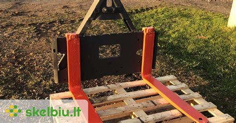 Schema, kaip tvirtinamas priekinis kaušas prie traktoriaus MTZ