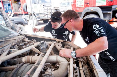 Autoserviso darbuotojai remontuoja automobilį
