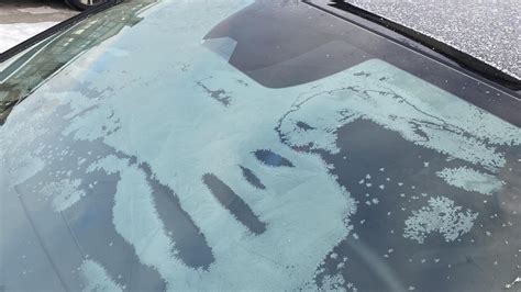 Žiemos metu užšalusi automobilio priekinis stiklas su sniegu