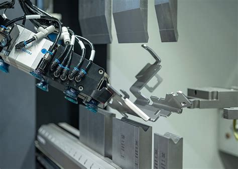 Robotizuota ranka surenka automobilio dalį