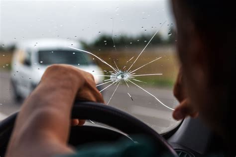 Akmenukas trenkiasi į automobilio stiklą