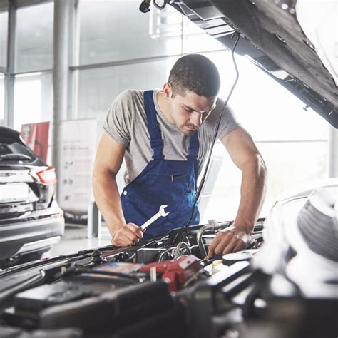 Automobilių mechanikas dirbantis su elektros sistema