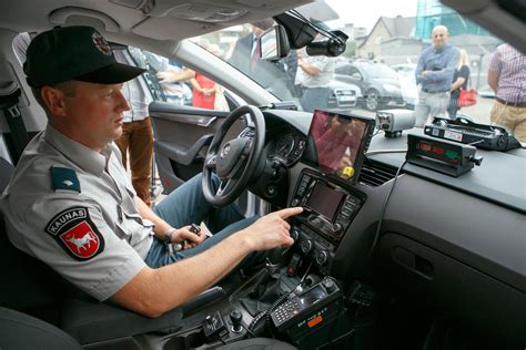 Simbolinis paveikslas su policijos pareigūnu ir greičio matuokliu