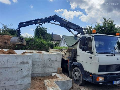 Savivartis su kranu, atliekantis pakrovimo darbus