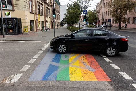 Nuotrauka su įvairių spalvų automobiliais, stovinčiais gatvėje