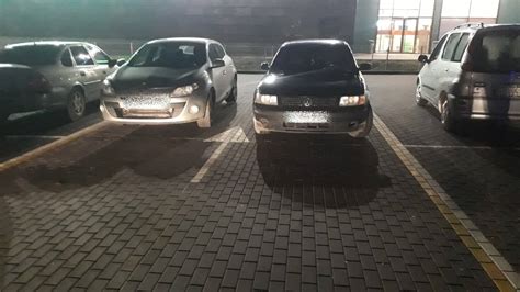 Žmonės parkuoja automobilius prekybos centro aikštelėje