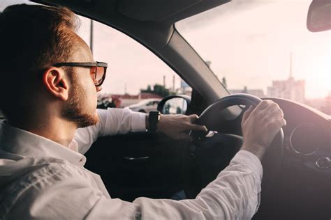 Vairuotojas su akiniais nuo saulės, žiūrintis į kelią