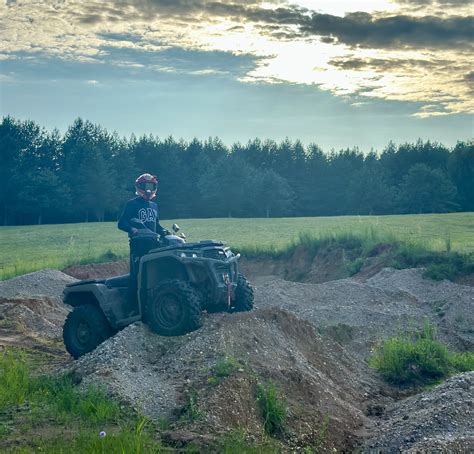 vaikas vairuojantis keturratį su suaugusiuoju