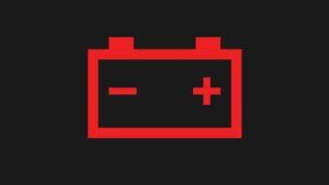 simbolis raudona akumuliatoriaus lempute ant automobilio prietaisų skydelio