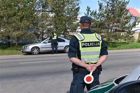 Nuotrauka ar iliustracija, vaizduojanti policijos pareigūną, duodantį signalą sustabdyti transporto priemonę