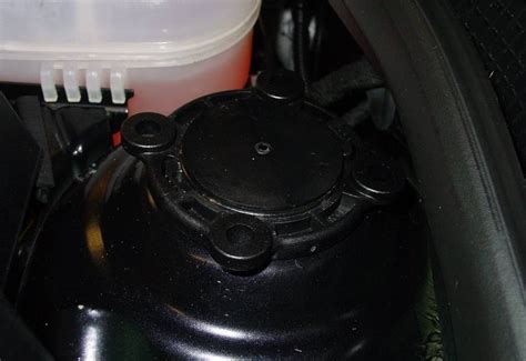 Pažeistas amortizatorius su matoma alyvos nuotėkiu