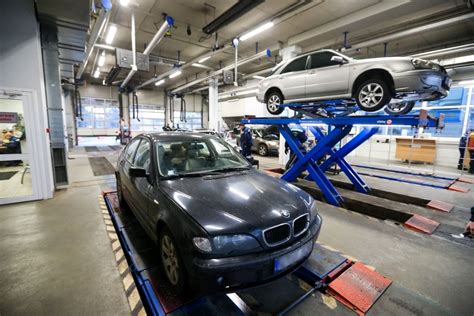 Darbuotojas autoservise atlieka automobilio techninę apžiūrą
