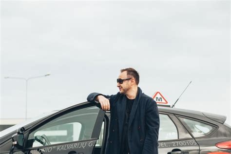 Instruktorius ir mokinys prie automobilio