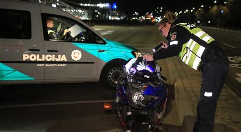 Motociklininkas dėvi ryškią aprangą ir šalmą