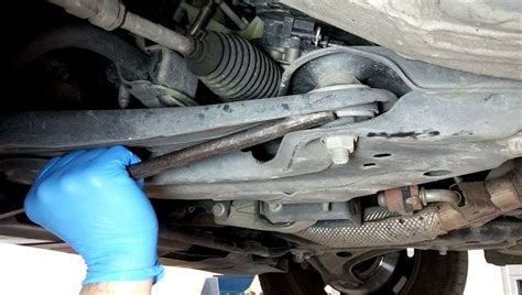 Serviso darbuotojai atlieka automobilio važiuoklės diagnostiką