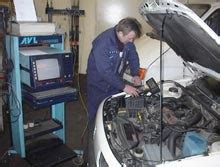 Darbuotojas autoservise atlieka automobilio diagnostiką