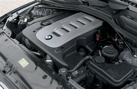 Vaizdas į atidarytą BMW E65 variklio skyrių su pažymėtu valdymo bloku