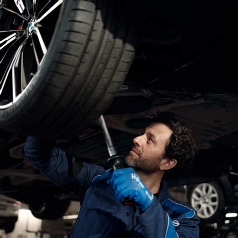 Serviso darbuotojas dirbantis su hibridiniu automobiliu