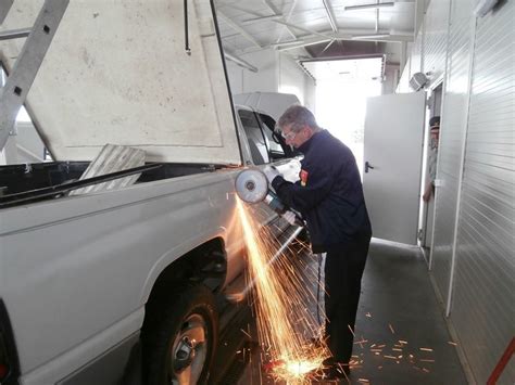 Darbuotojas šlifuoja automobilio kėbulą