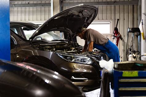 Nuotrauka su serviso darbuotojais, atliekančiais Ford automobilio diagnostiką