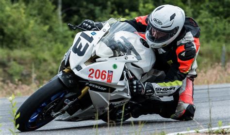 Motociklininkas su apsaugine apranga trasoje