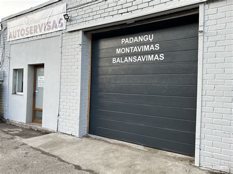 Autoserviso darbuotojai montuoja padangas