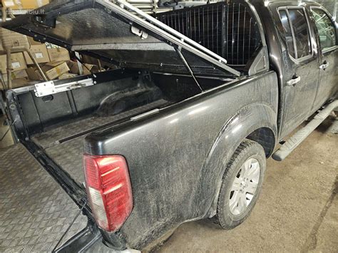 Darbuotojai dirbantys su Nissan Navara automobilio bagažinės dangčiu