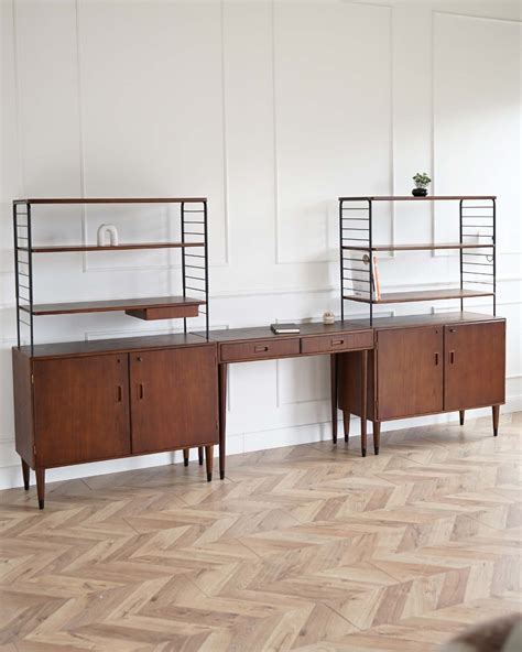 Simbolis: skritulys su šauktuku viduje ir skliausteliais iš šonų